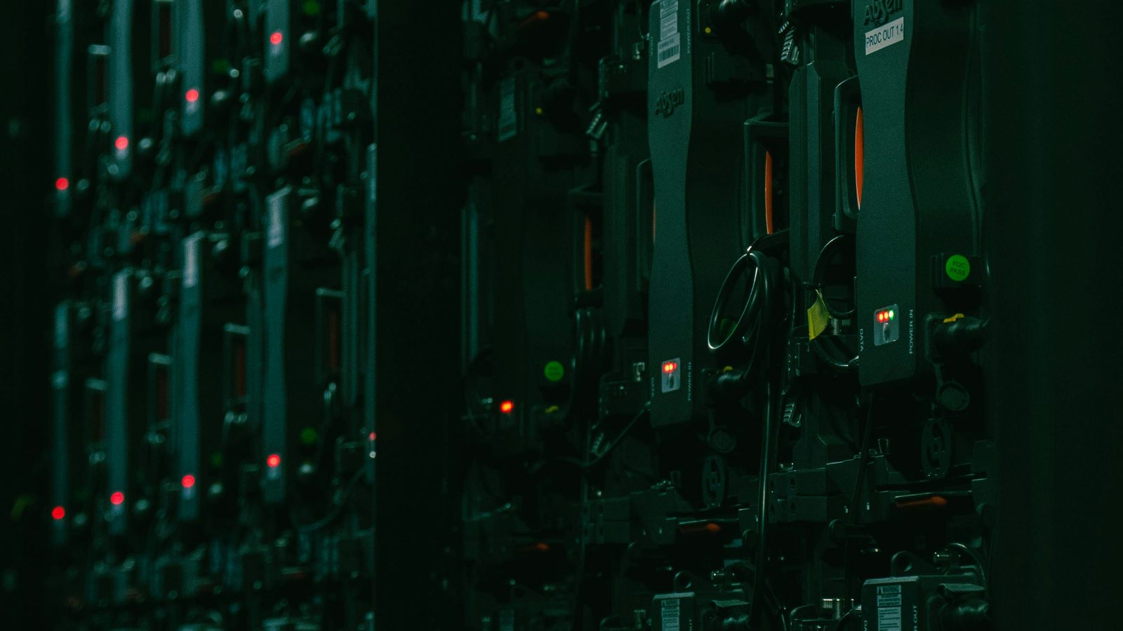Rows of server racks in a dark data centre, the frame split down the middle by a vertical column